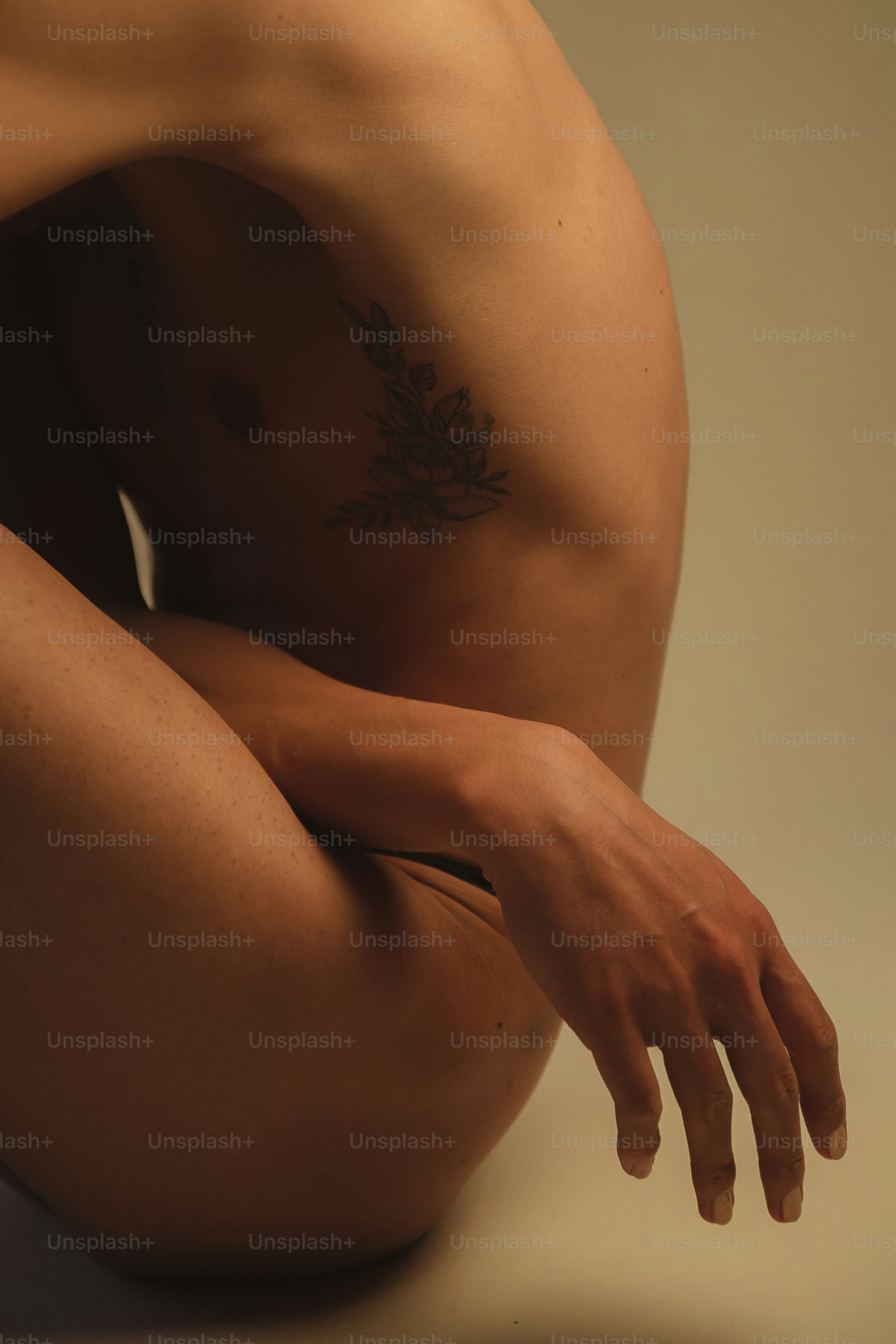 a man with a tattoo on his arm sitting on the ground