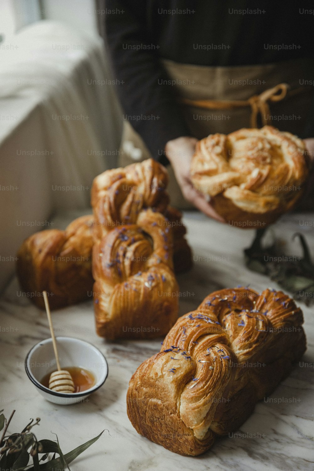 a table topped with croissants and a bowl of honey