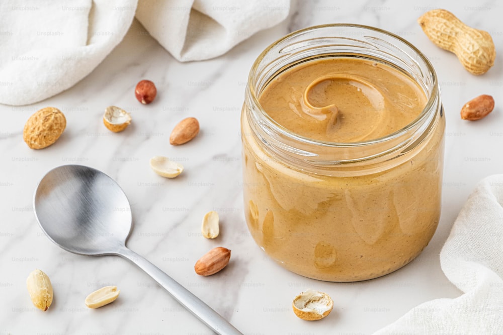 a jar of peanut butter next to a spoon