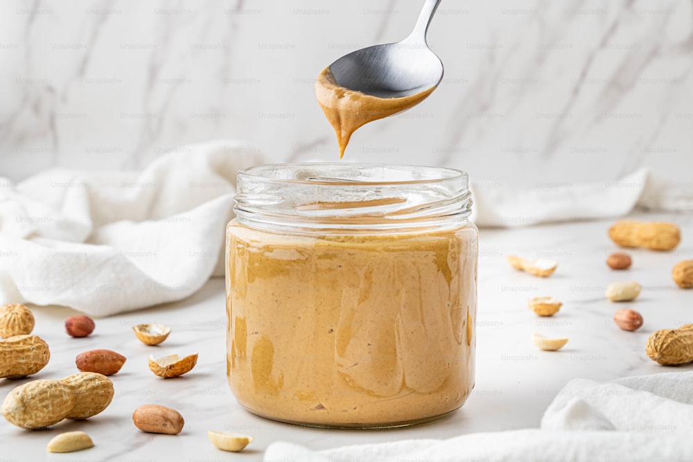 a jar of peanut butter with a spoon full of peanut butter