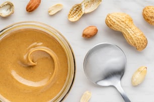 a jar filled with peanut butter next to a spoon
