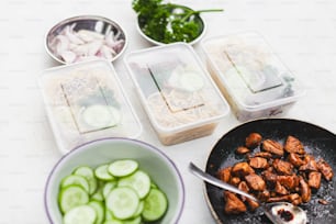 a table topped with bowls of food and a bowl of cucumbers