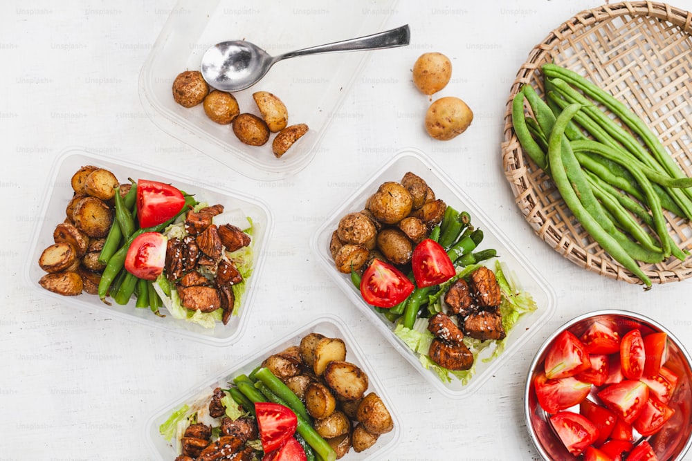 a table topped with plastic containers filled with food