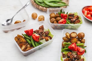 a table topped with plastic containers filled with food