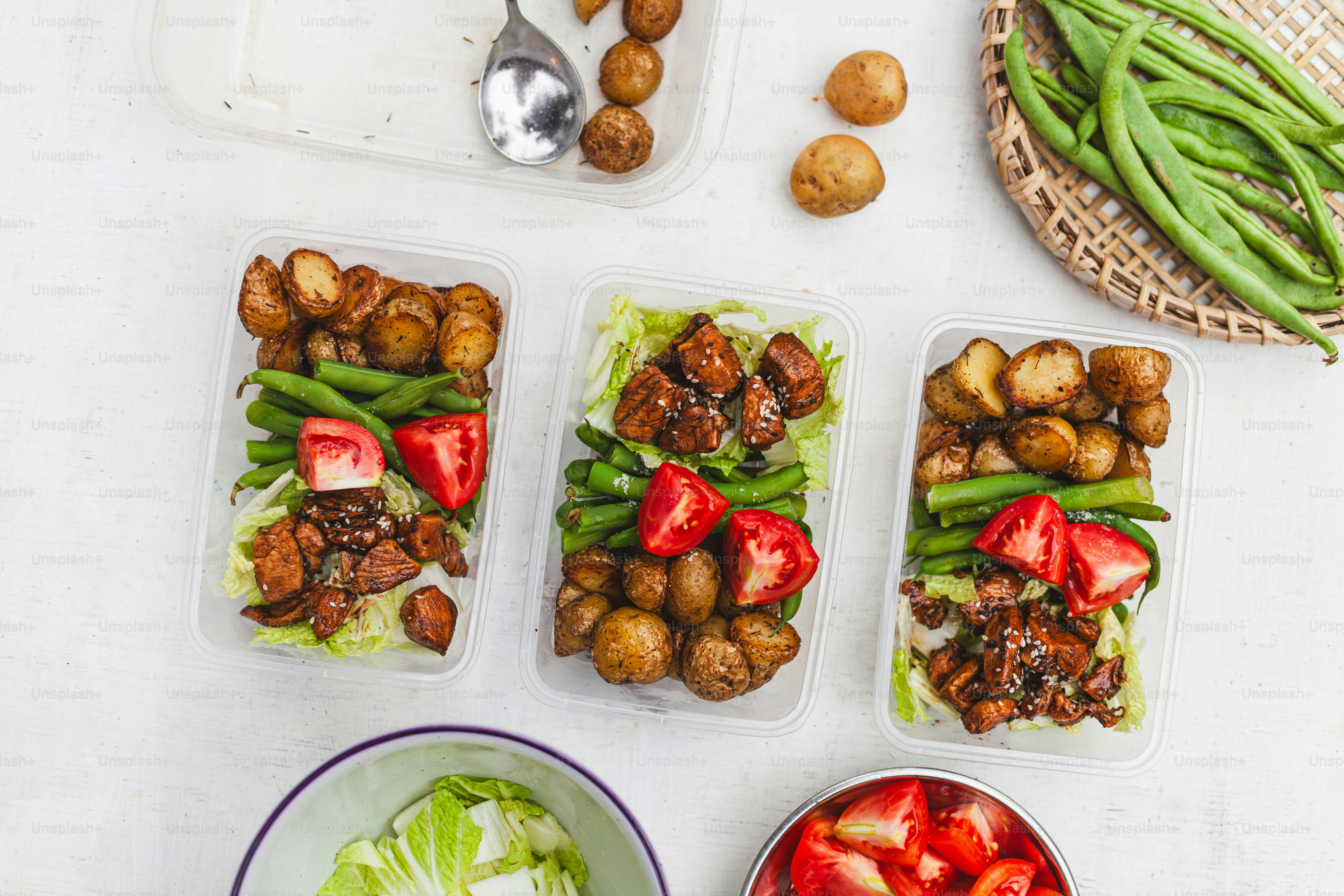 a table topped with plastic containers filled with food