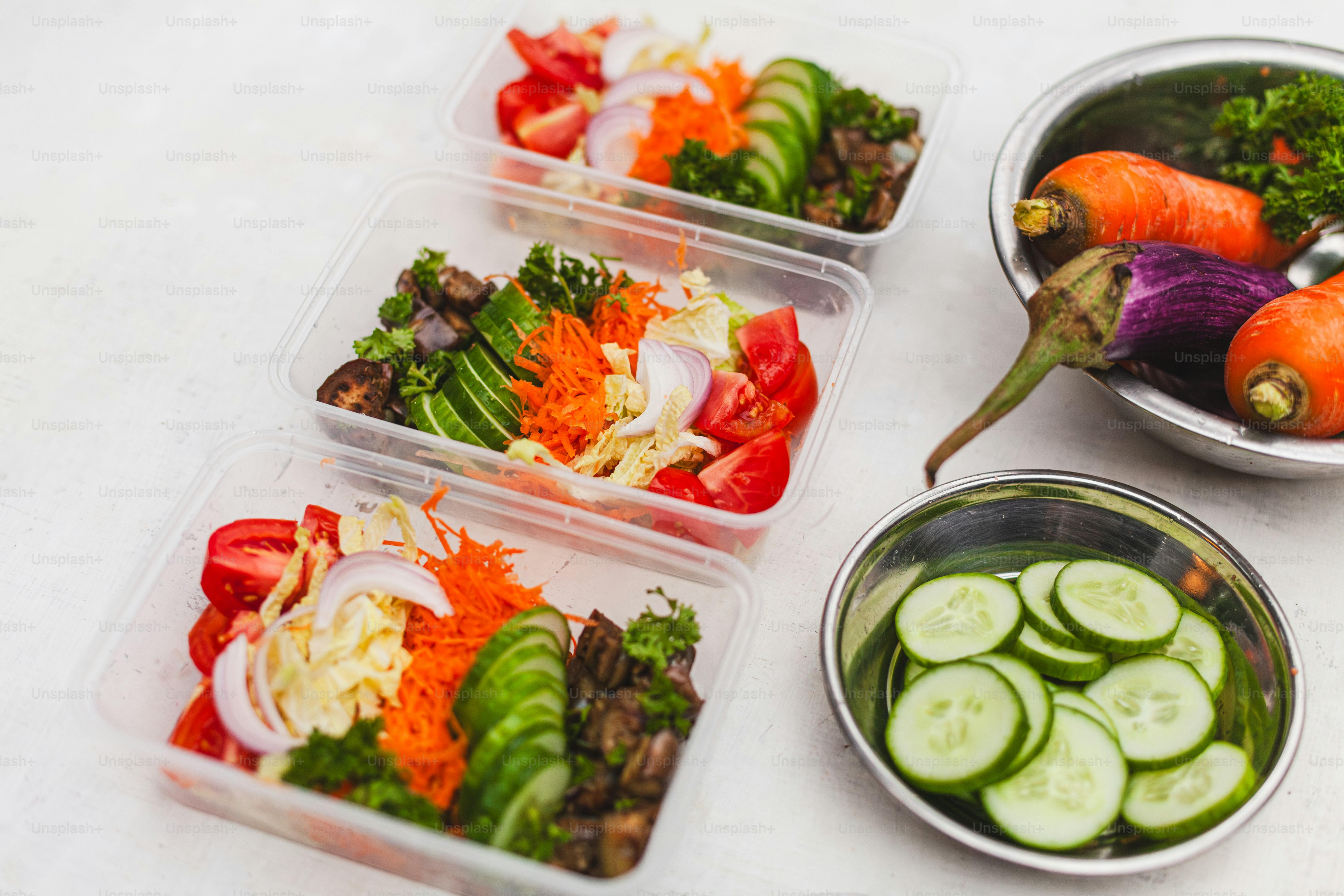 a table topped with four plastic containers filled with veggies
