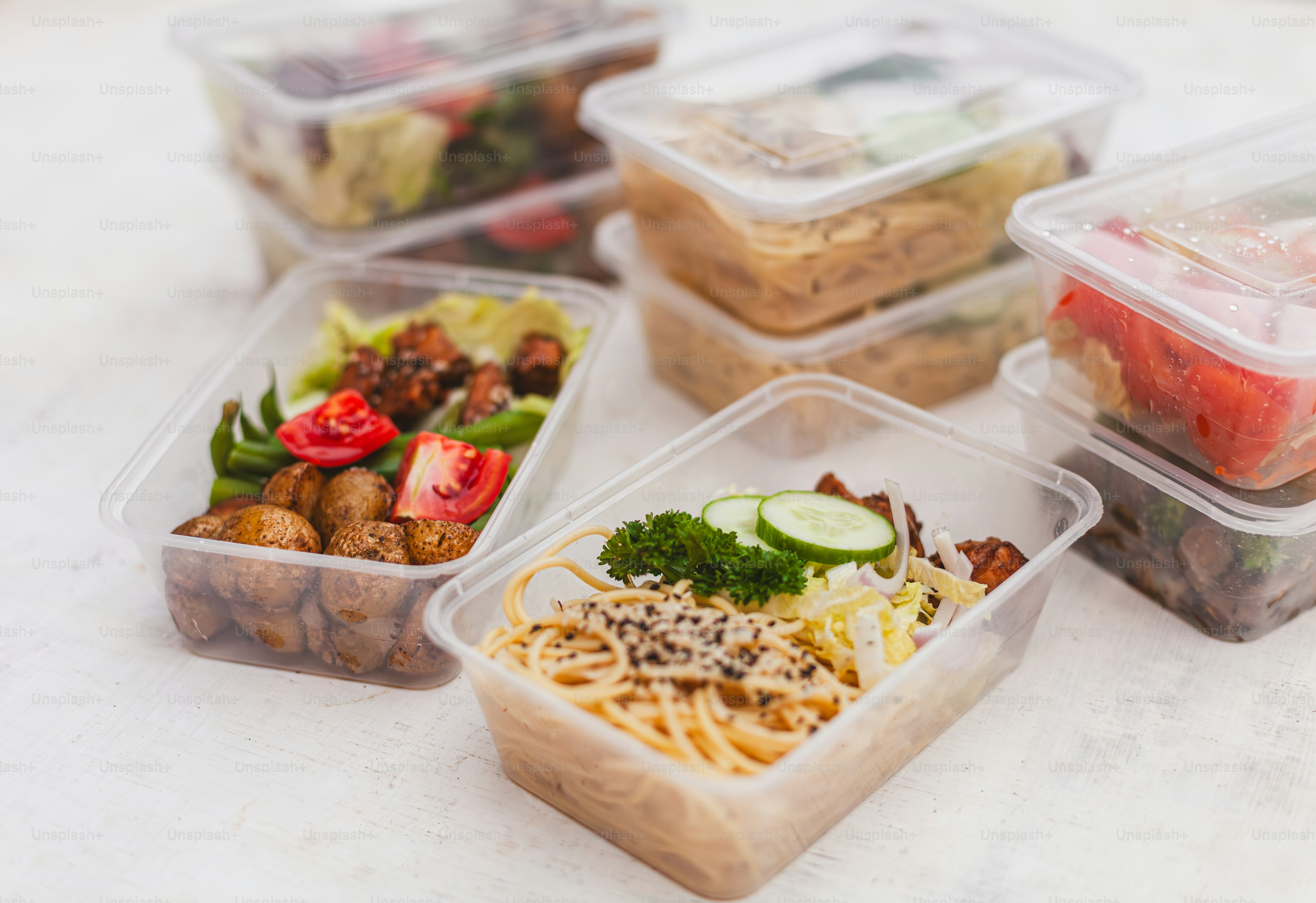 a table topped with plastic containers filled with food