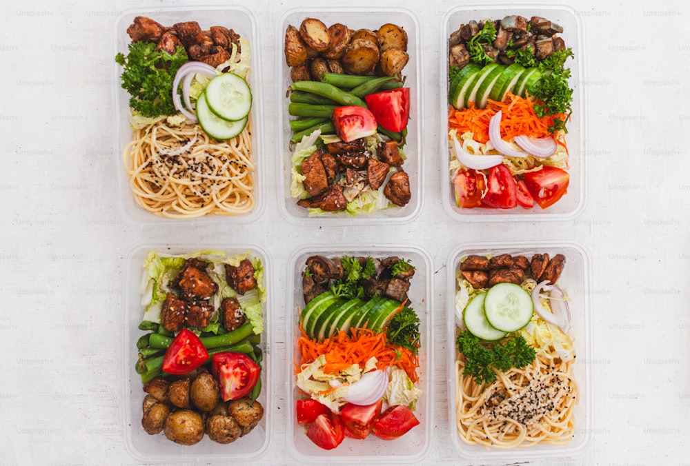 Sechs Kunststoffbehälter, gefüllt mit verschiedenen Arten von Lebensmitteln