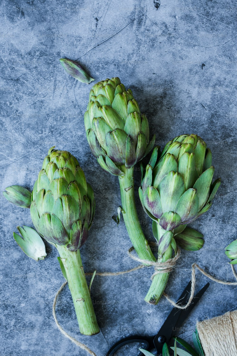 a bunch of artichokes sitting on a table next to a pair of