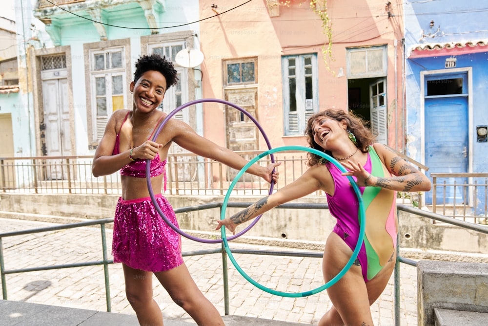two women in bathing suits holding hoop rings
