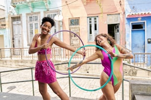 two women in bathing suits holding hoop rings