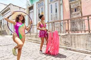two women in bathing suits holding hoops and posing for a picture