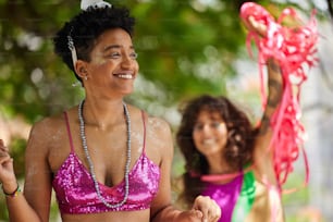 a woman in a pink bikini top standing next to another woman in a purple bikini