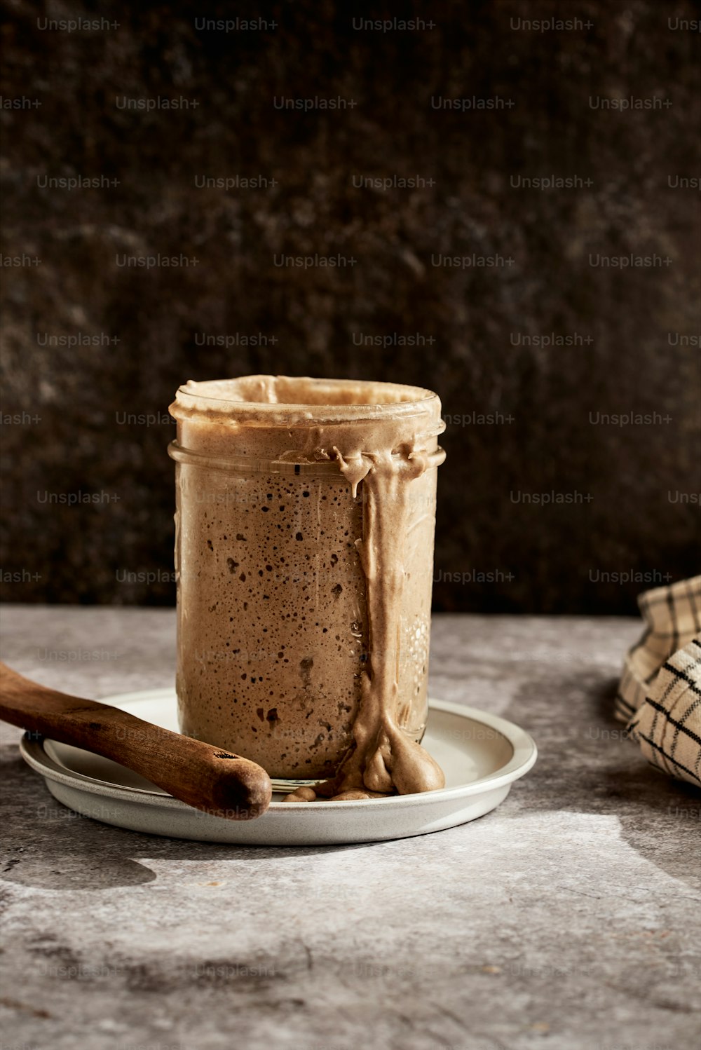 a jar of peanut butter on a plate with a spoon