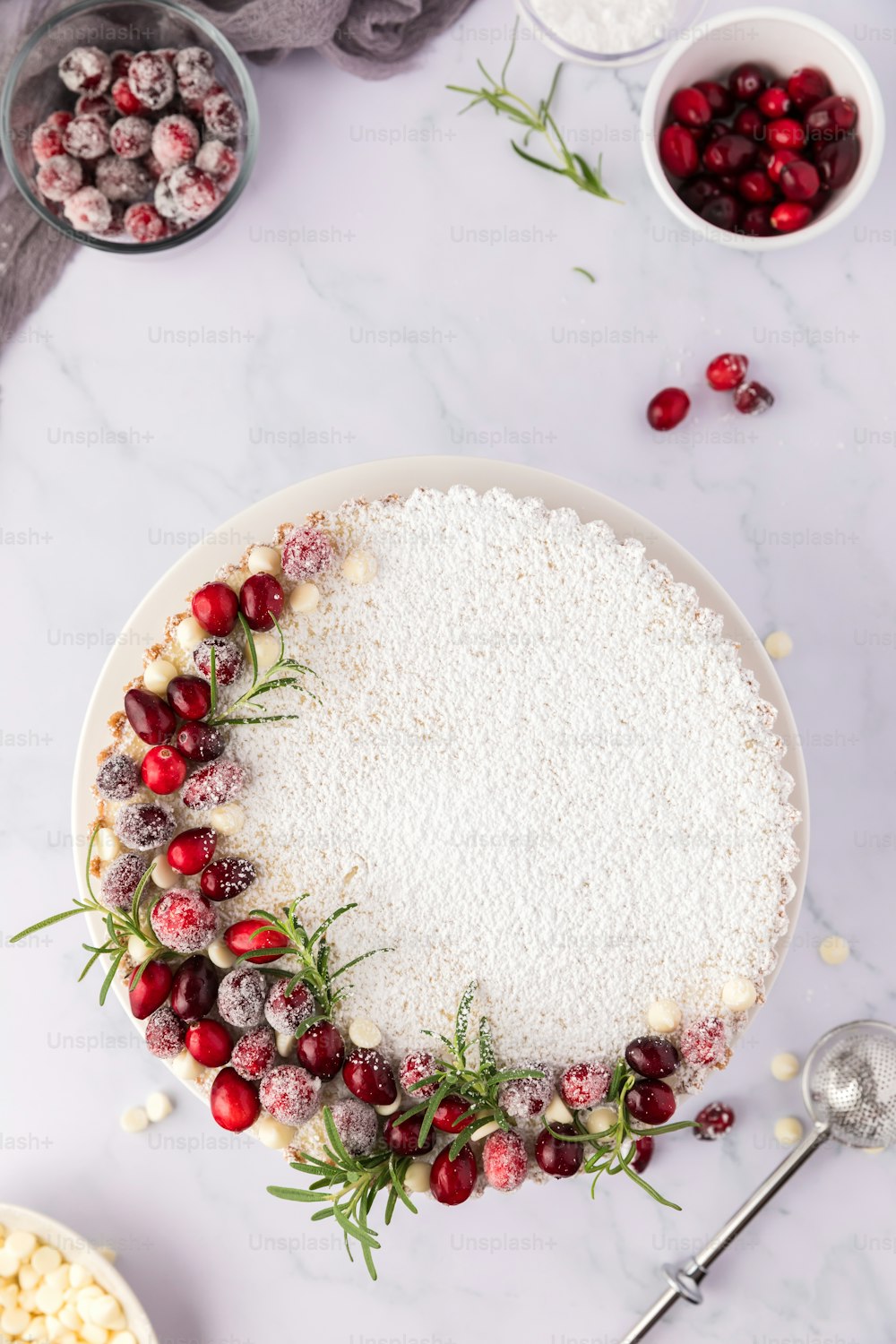 um prato branco coberto com um bolo coberto de cranberries