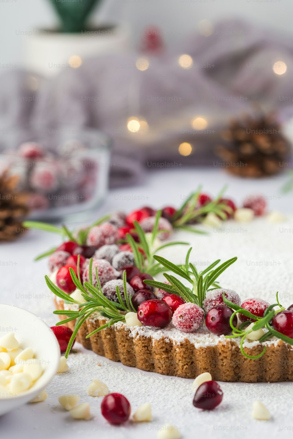 a table topped with a cake covered in frosting and cranberries
