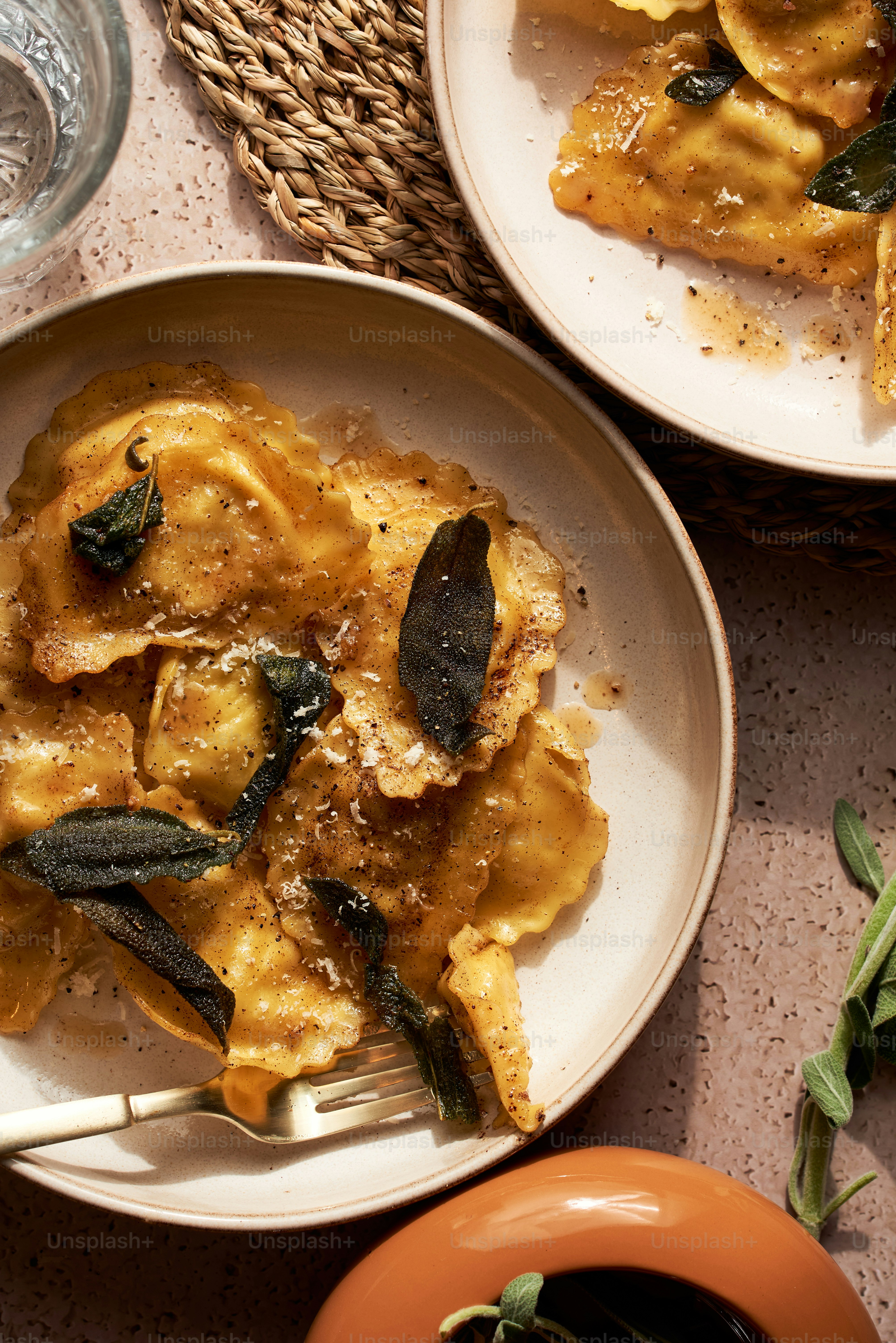 a plate of ravioli with sage leaves on top
