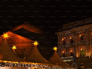 a large tent with lights on it in front of a building