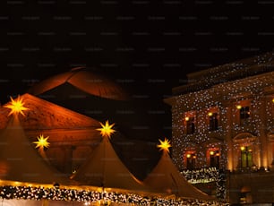 a large tent with lights on it in front of a building