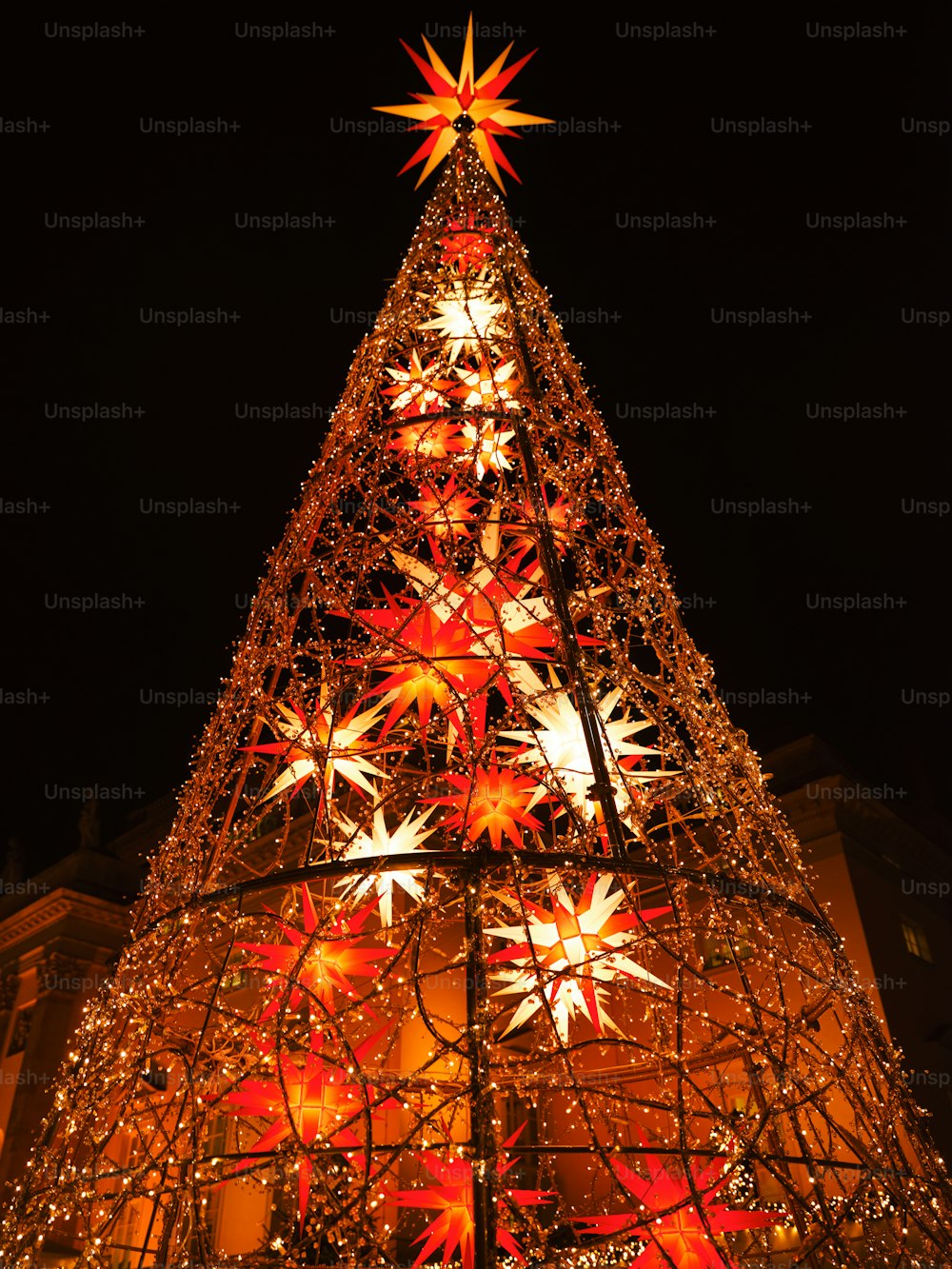 a lighted christmas tree in front of a building