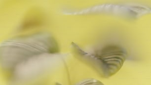 uma foto desfocada de folhas em um fundo amarelo