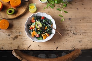 eine Schüssel Salat auf einem Holztisch