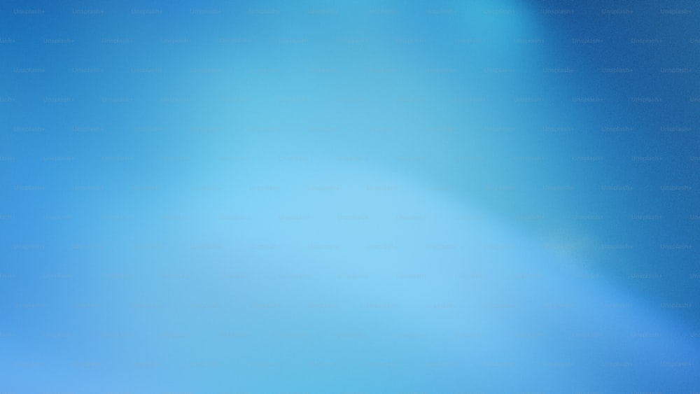 Ein verschwommenes Bild eines blauen Himmels mit einem Flugzeug in der Ferne