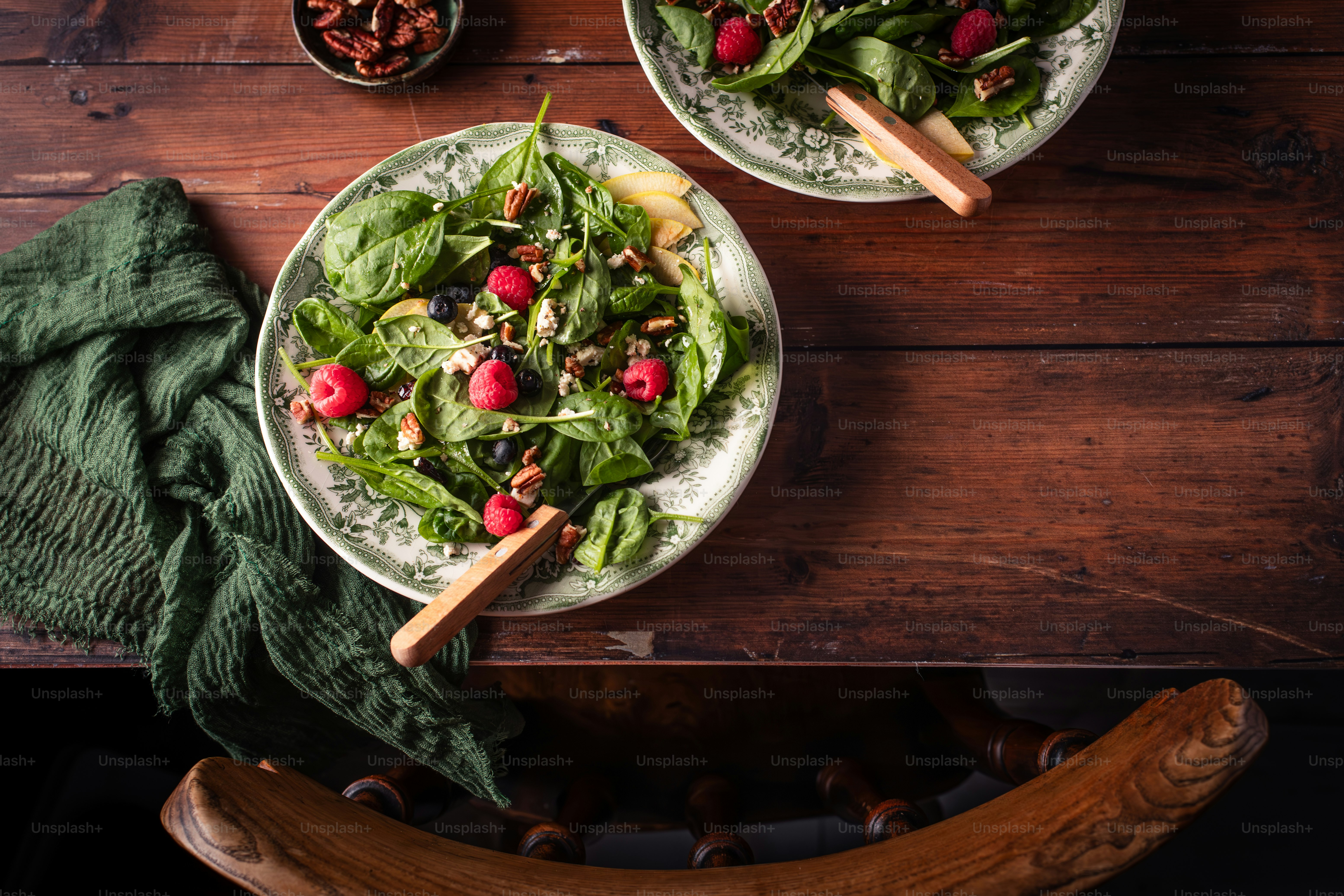 two plates of salad on a wooden table