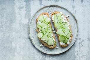 a sandwich with cucumber and cream on a plate