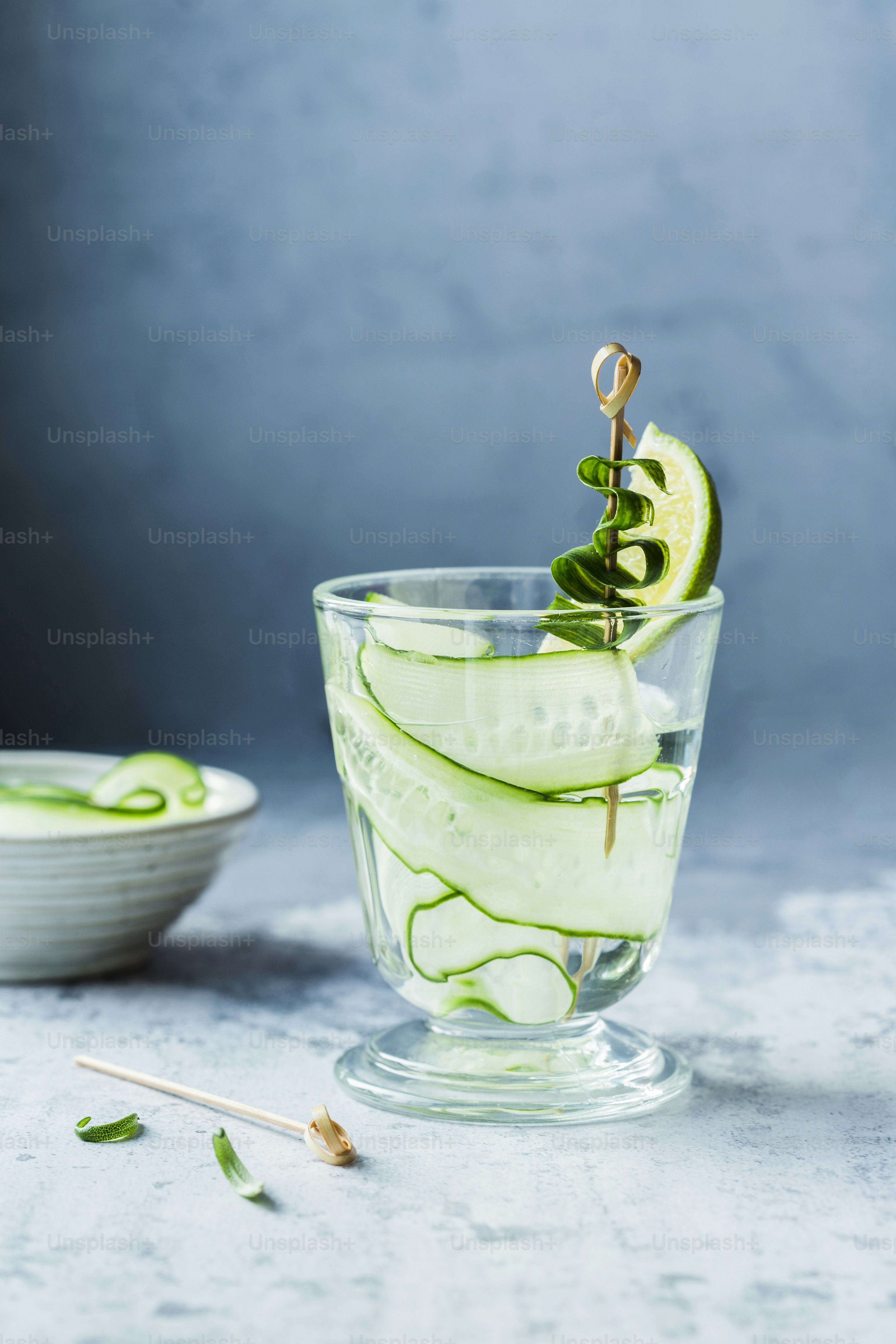um copo cheio de pepino e uma fatia de limão
