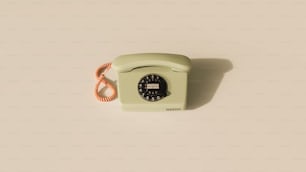 an old green phone with a cord attached to it