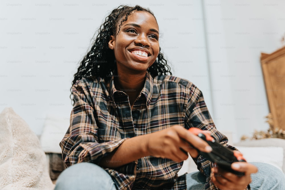 a woman sitting on a couch holding a remote control