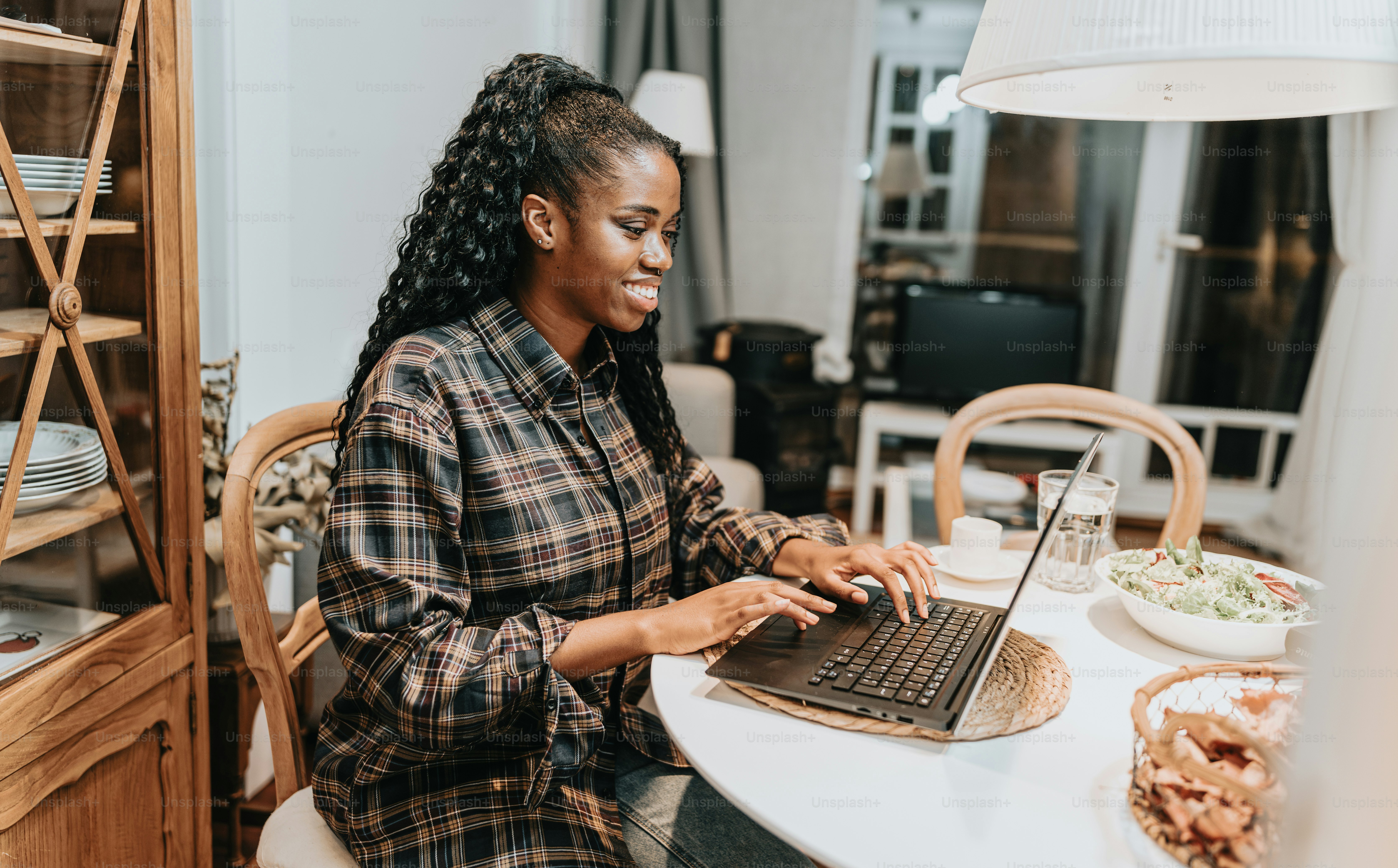 a woman sitting at a table using a laptop computer