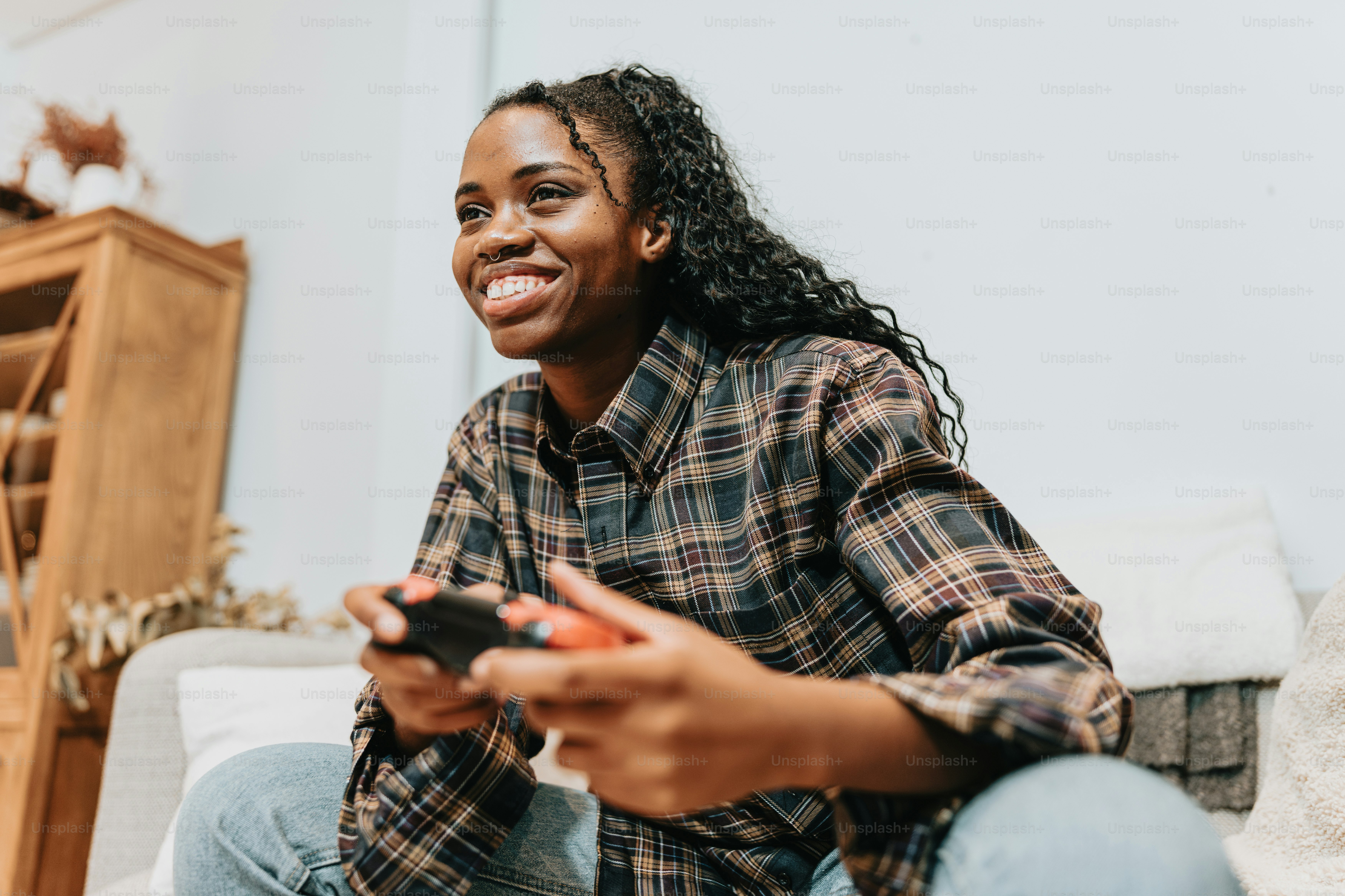 a woman sitting on a couch holding a remote control