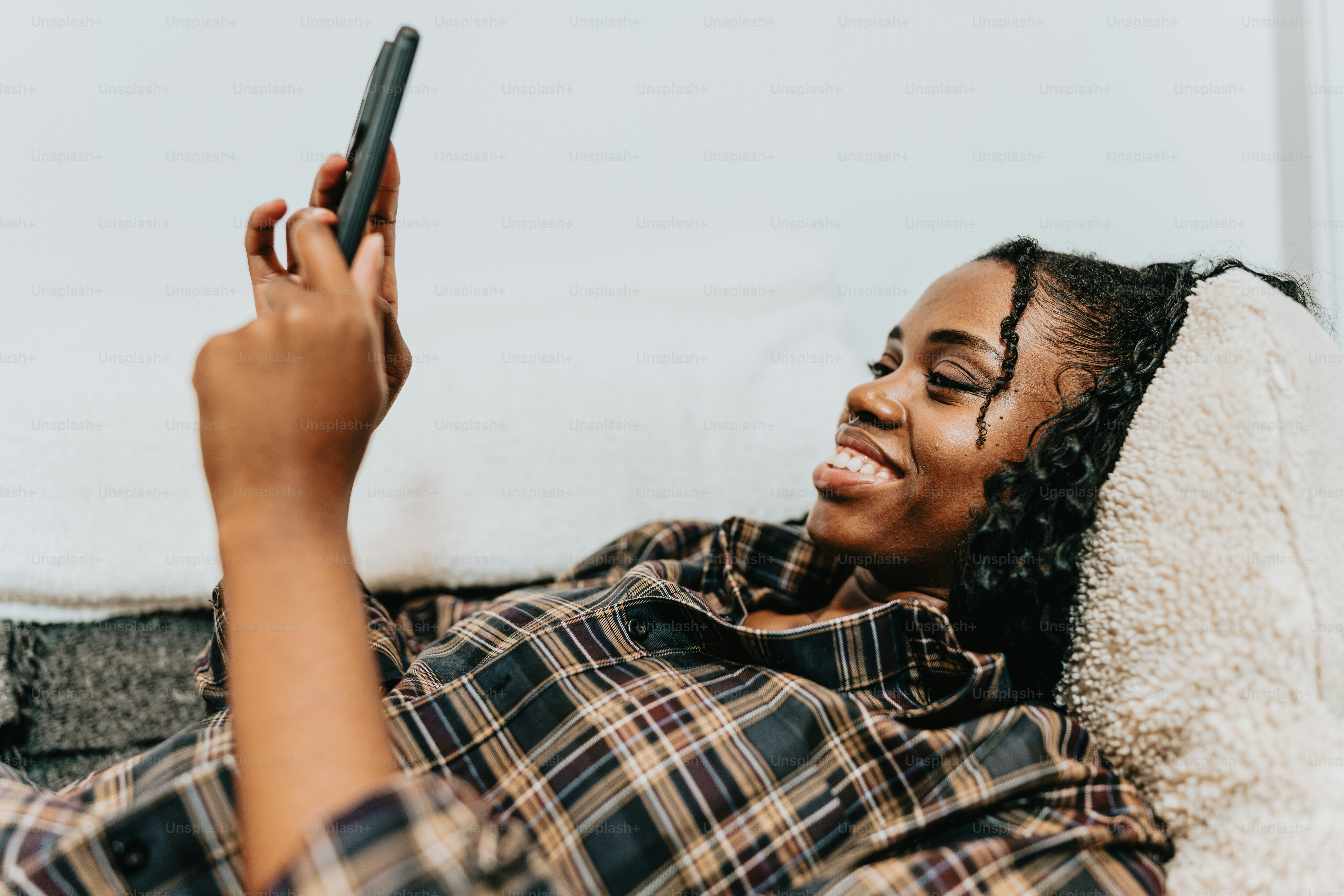 ソファに横たわり、携帯電話を手にする女性
