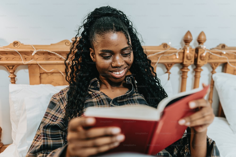 a woman sitting on a bed reading a book