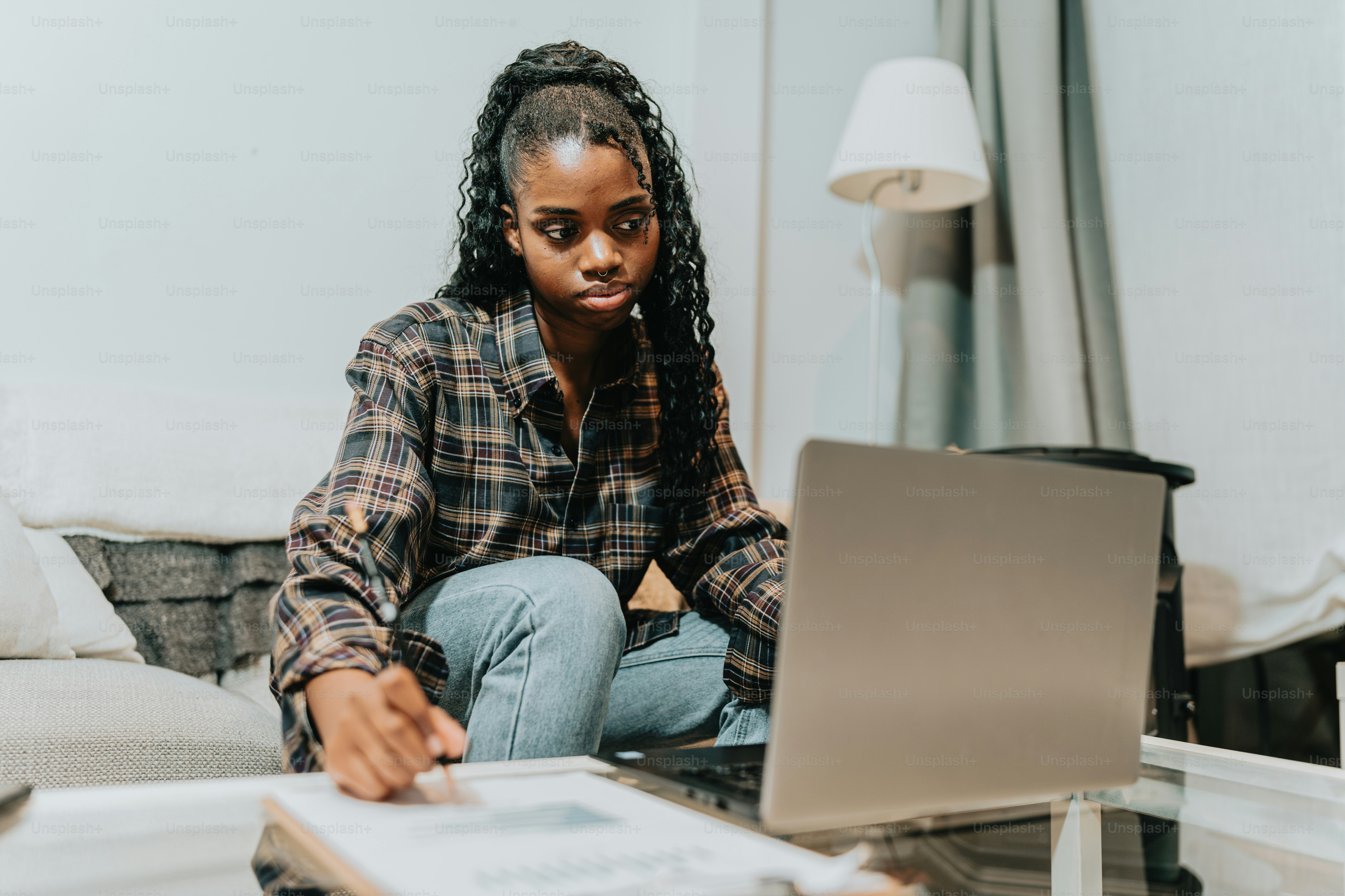 a woman sitting on a couch looking at a laptop