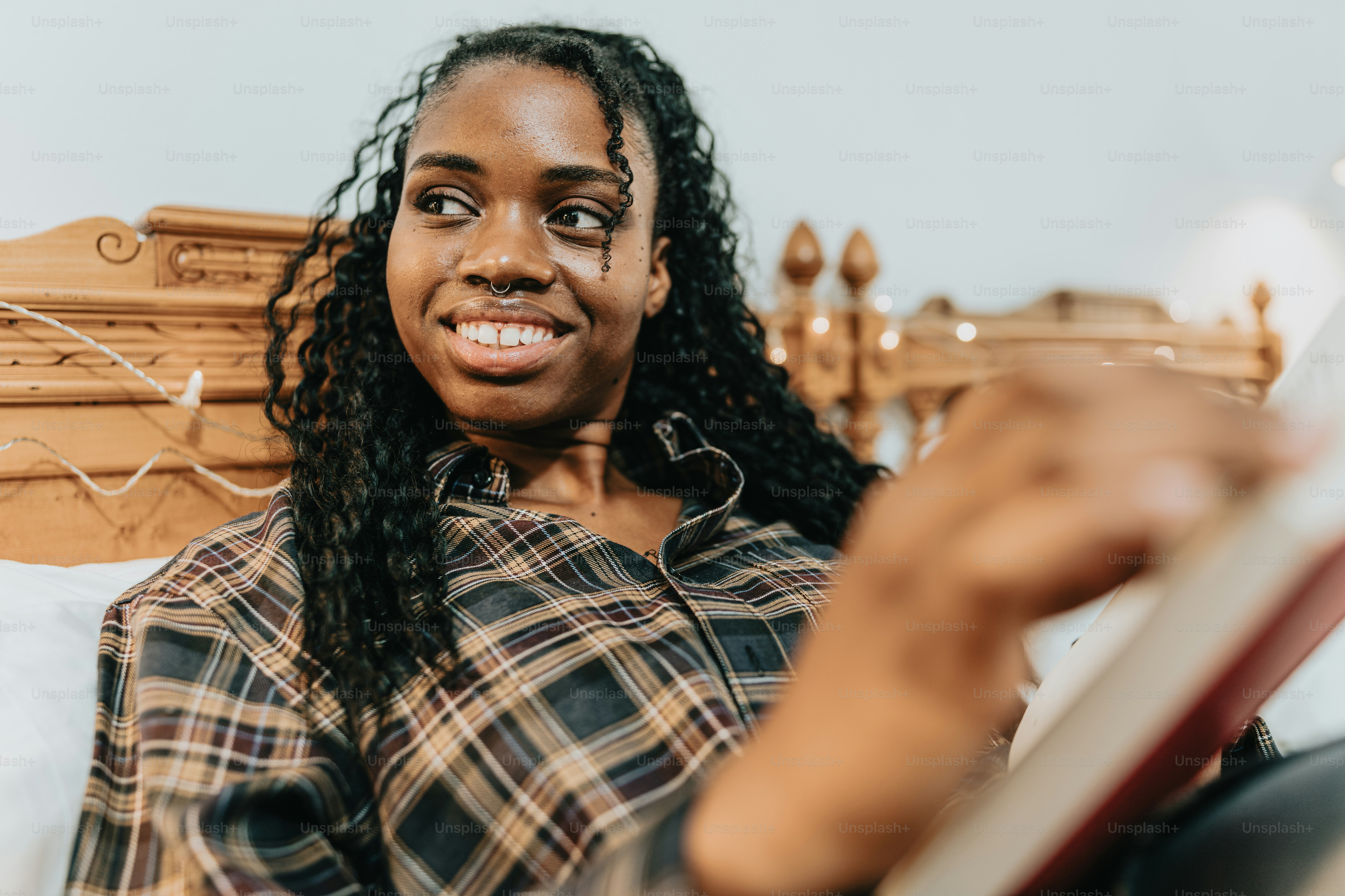 a woman sitting on a bed reading a book