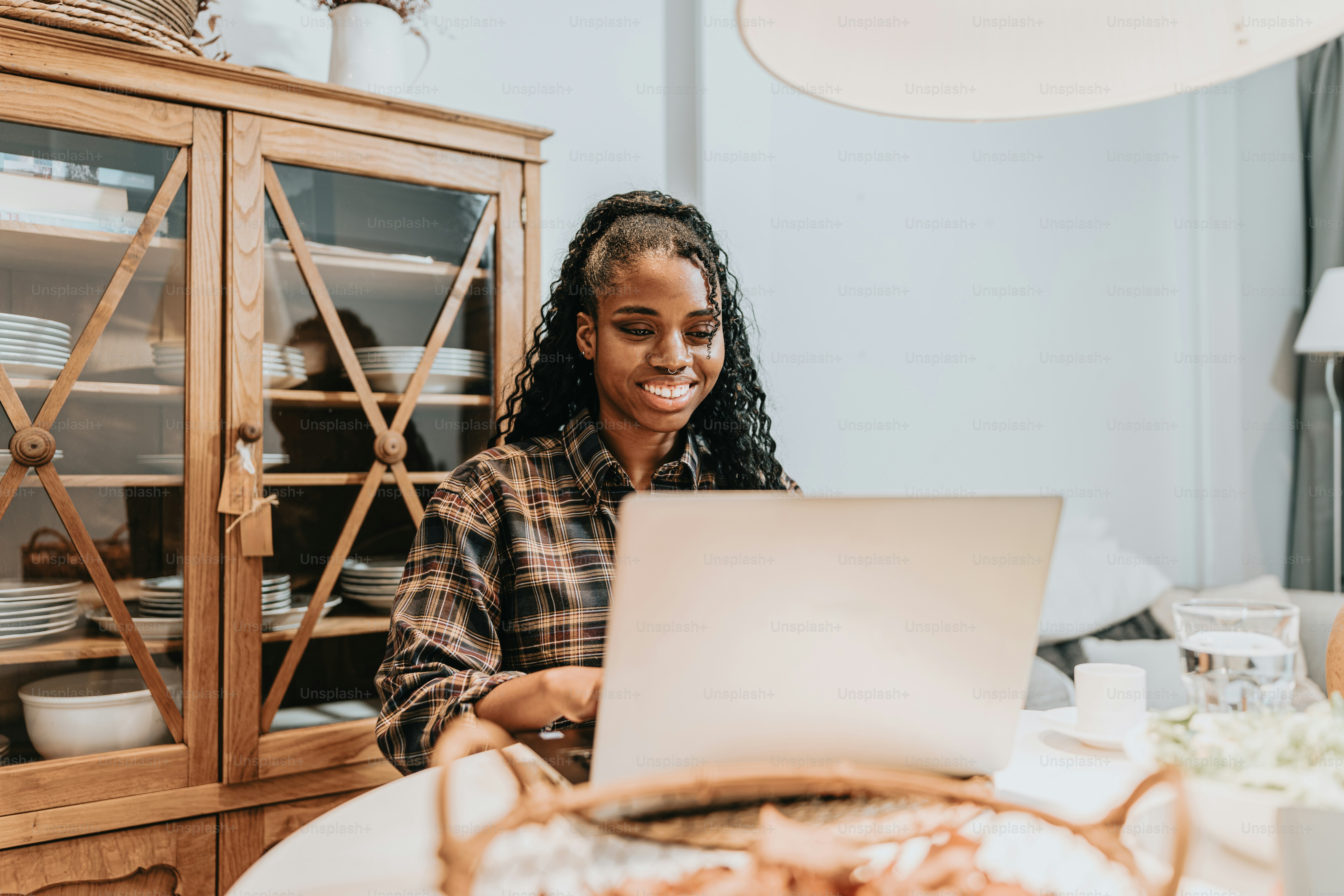 a woman sitting at a table using a laptop computer