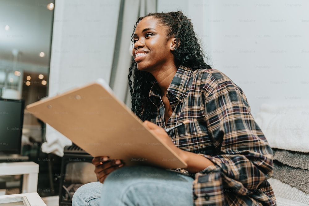 a woman sitting on the floor looking at a piece of paper