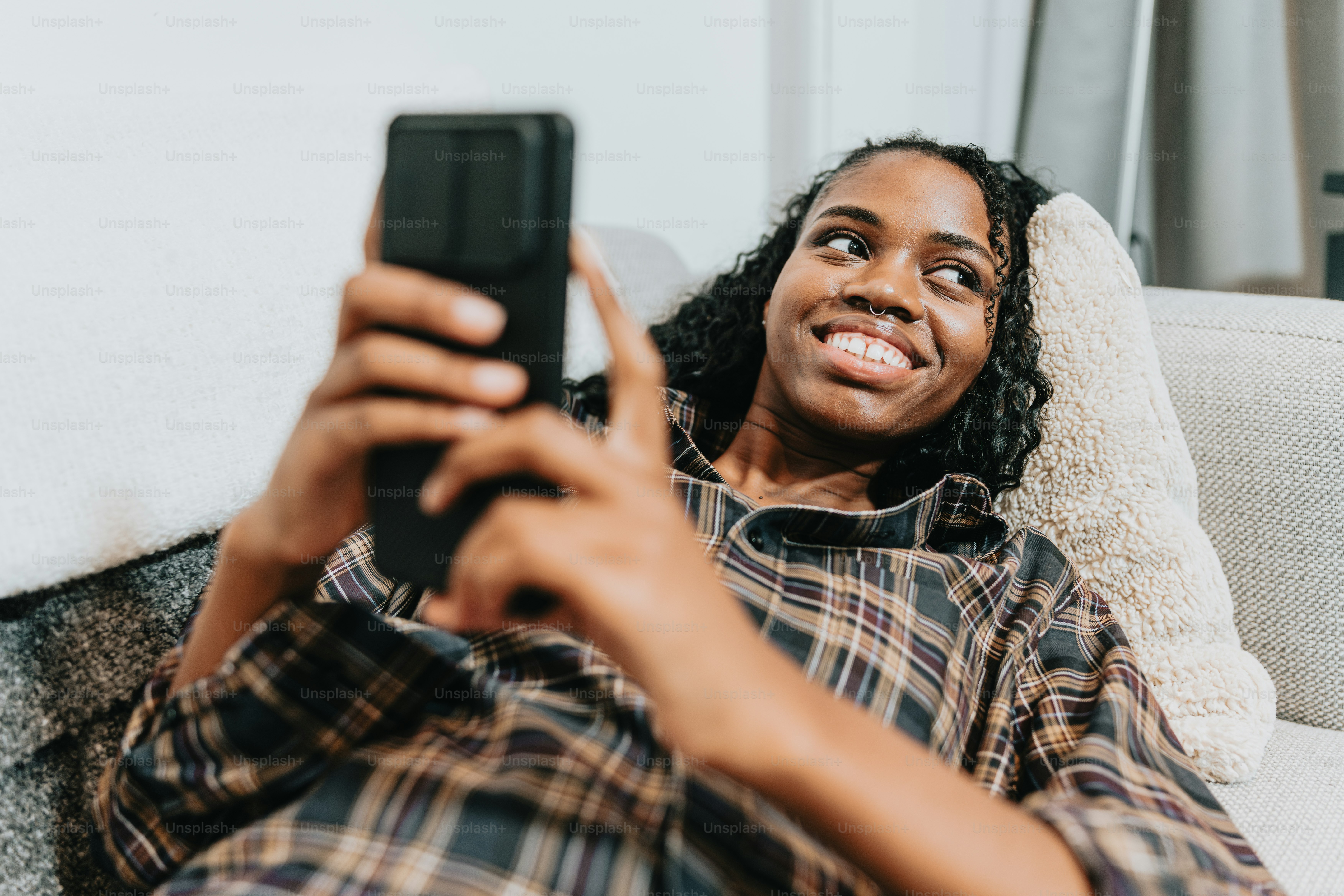 a woman sitting on a couch holding a cell phone
