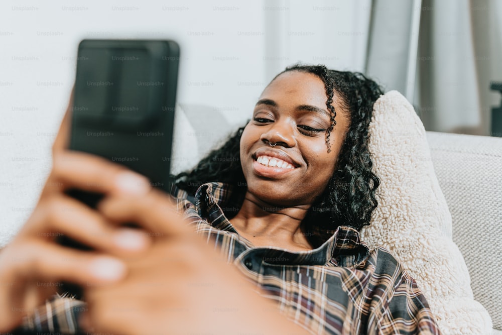 a woman sitting on a couch looking at her cell phone