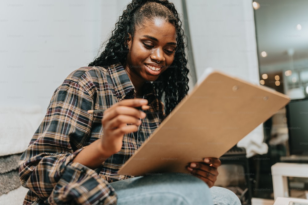 a woman sitting on the floor looking at a piece of paper