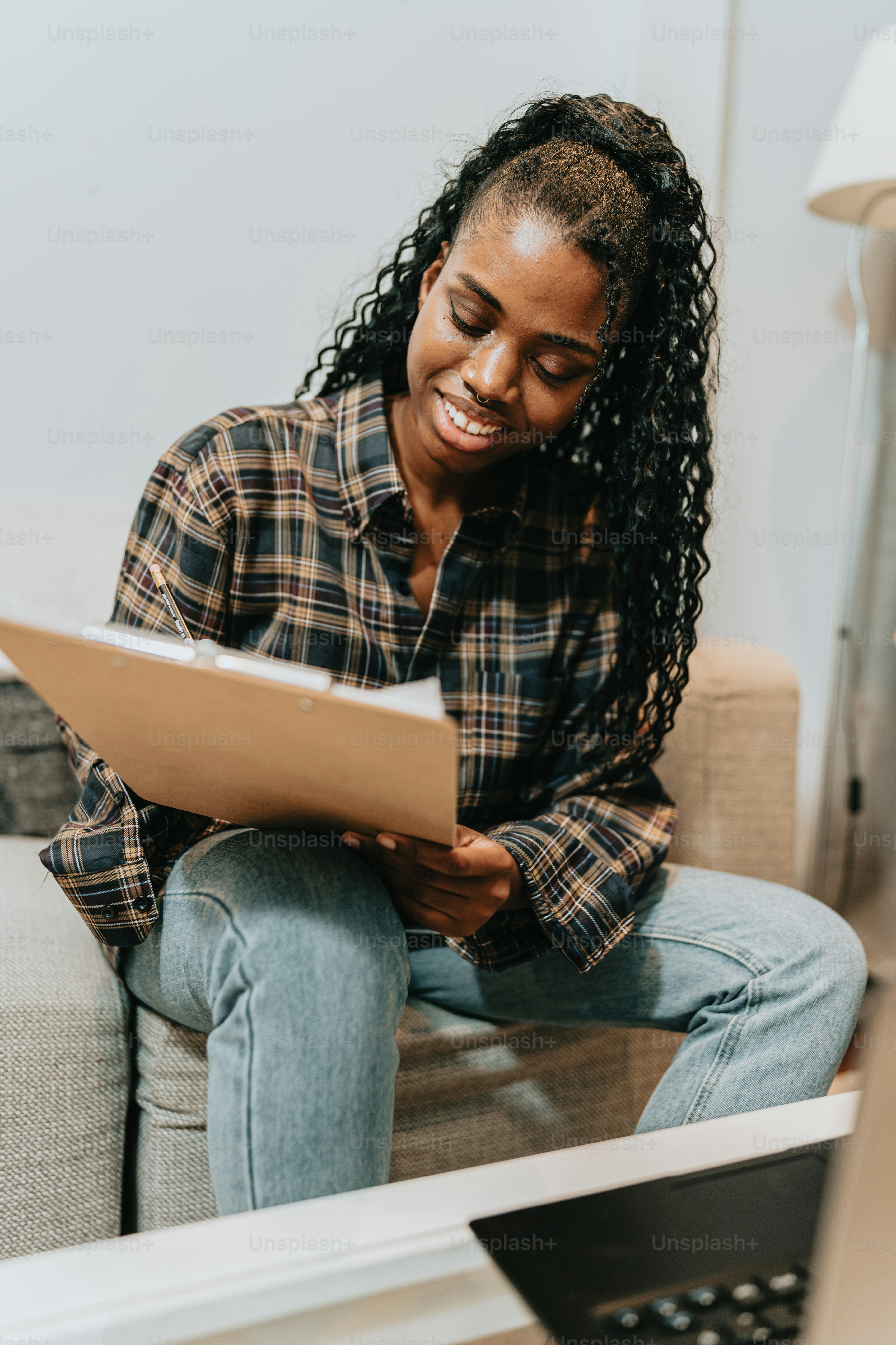 a woman sitting on a couch looking at a piece of paper