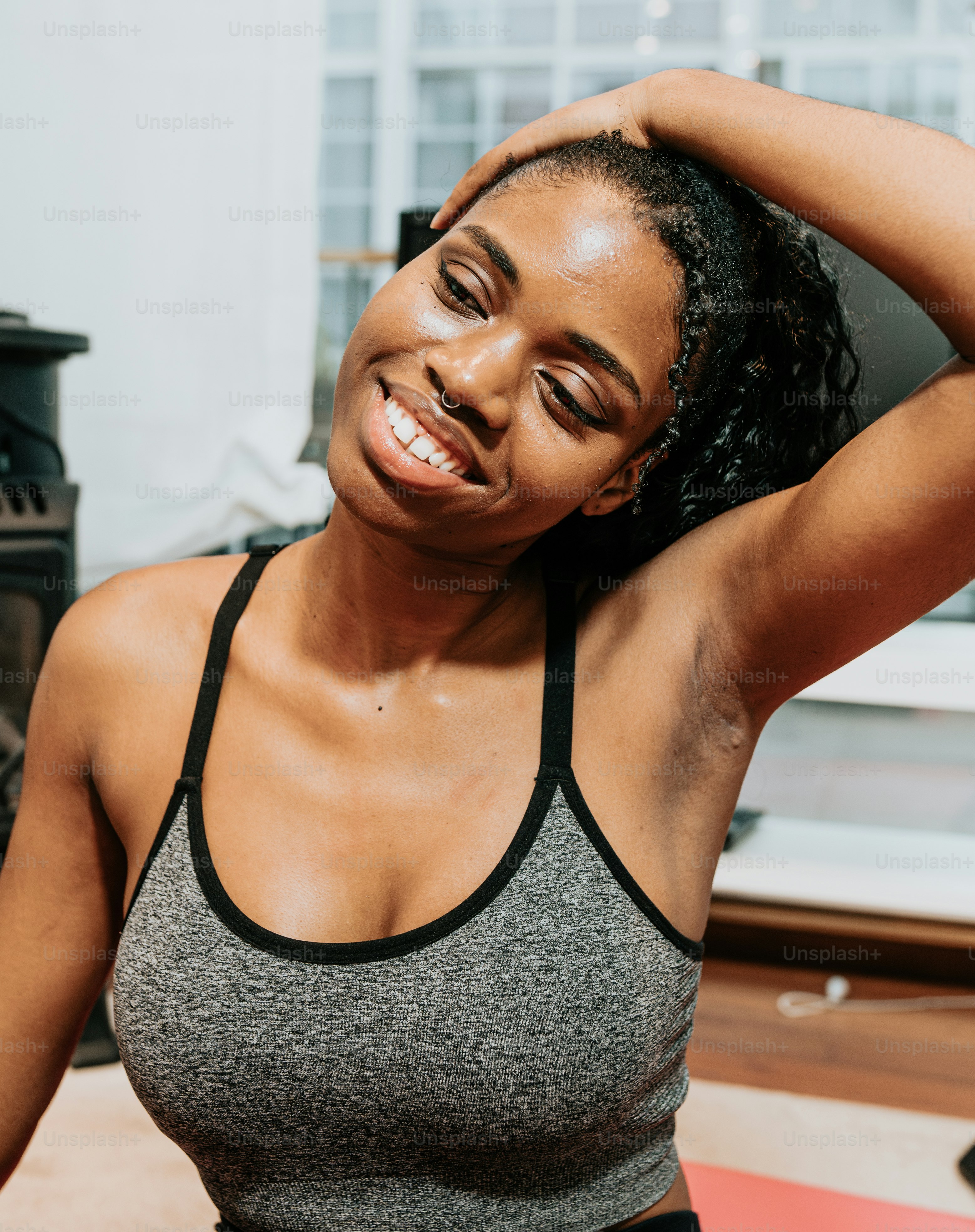a woman in a gray tank top is smiling