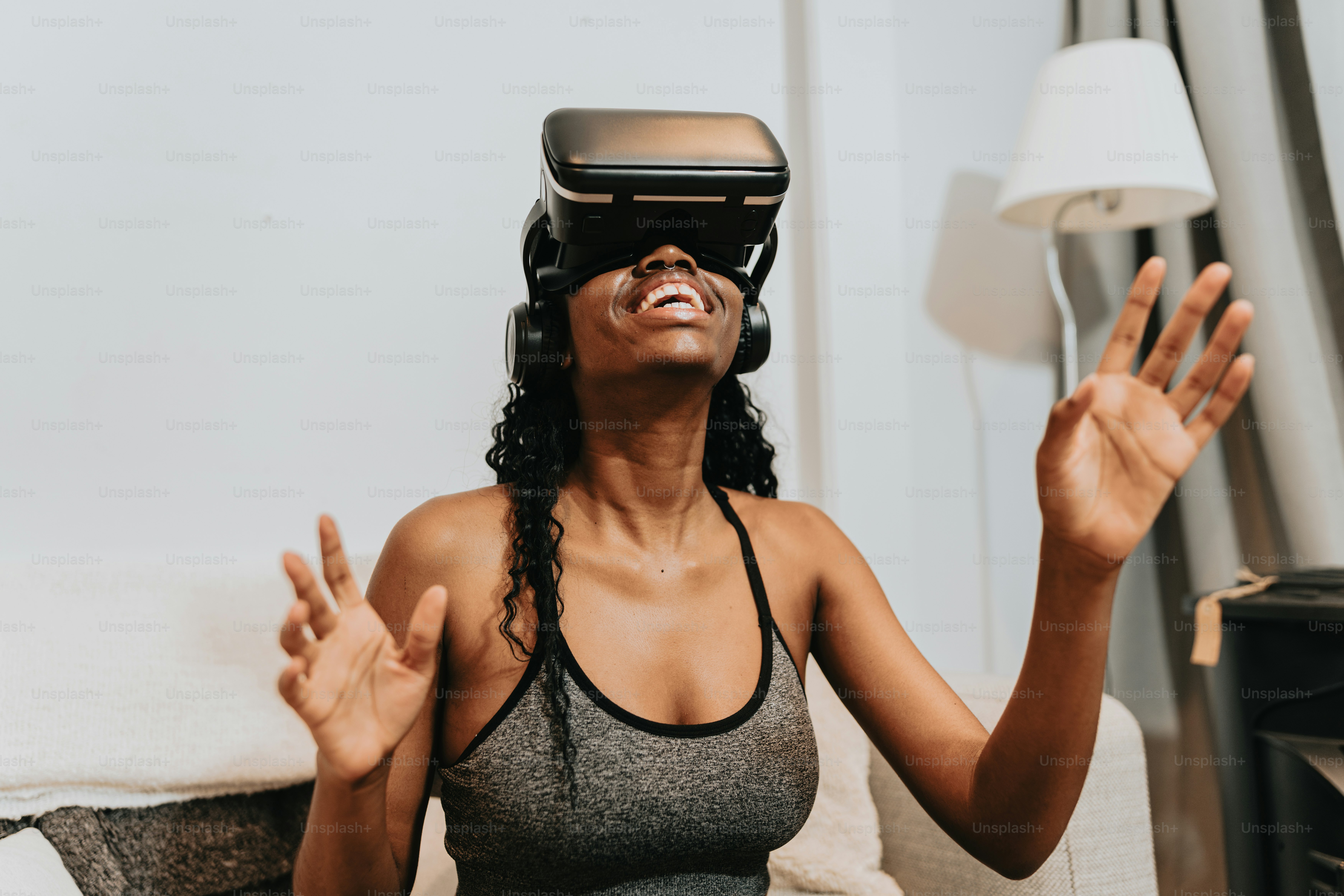 una donna seduta su un divano che indossa un visore per realtà virtuale
