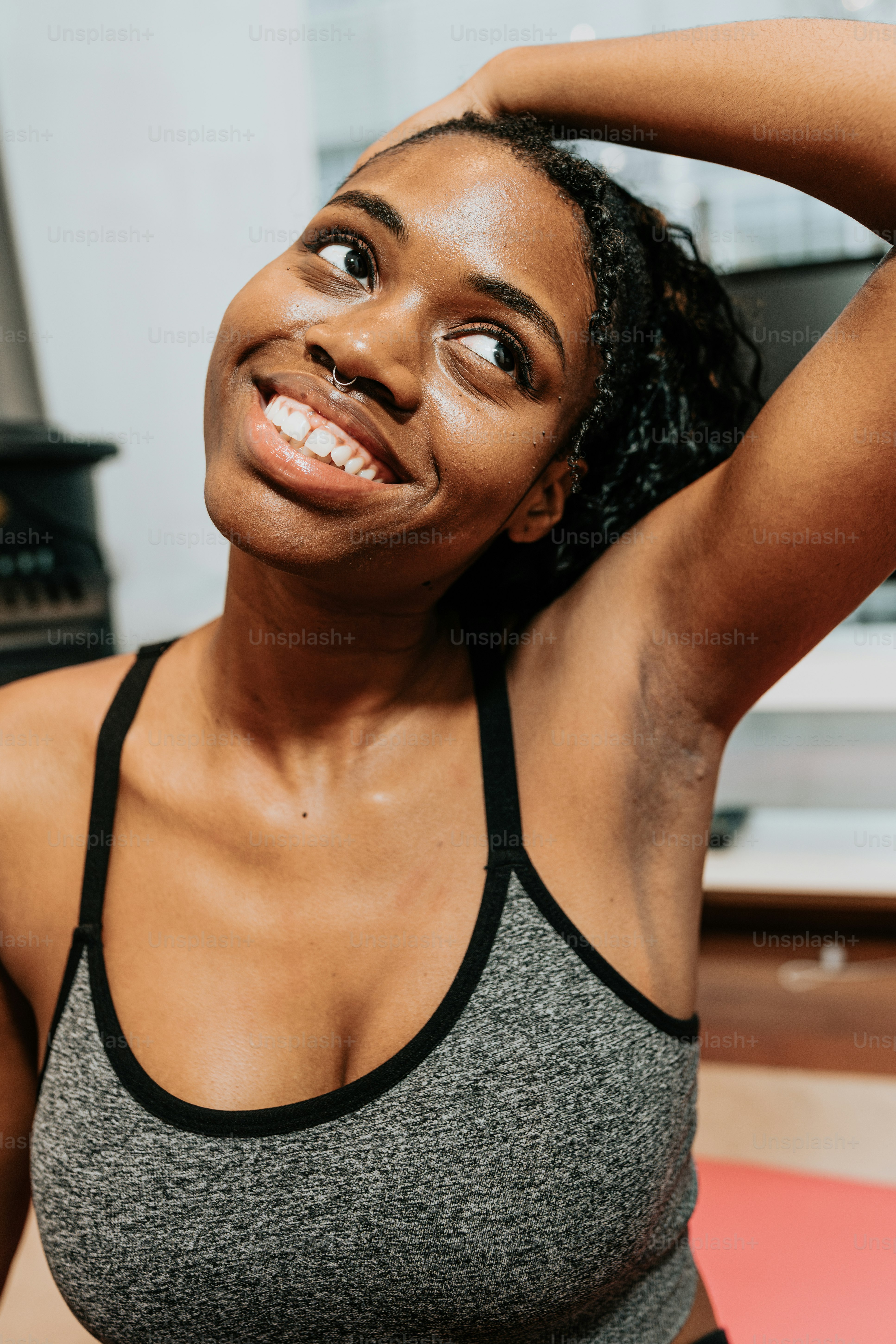 a woman in a gray and black top is smiling