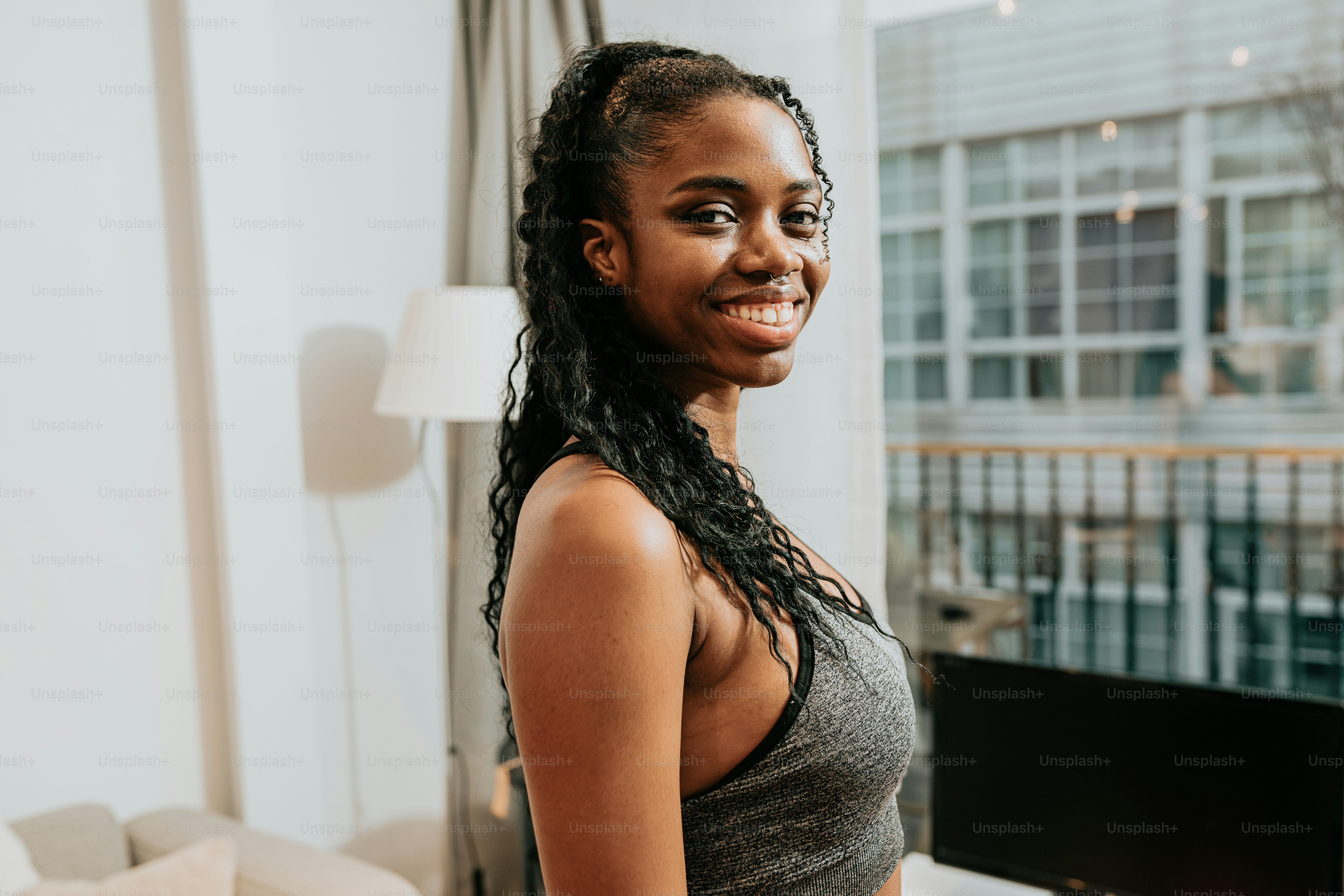 a woman standing in front of a window smiling