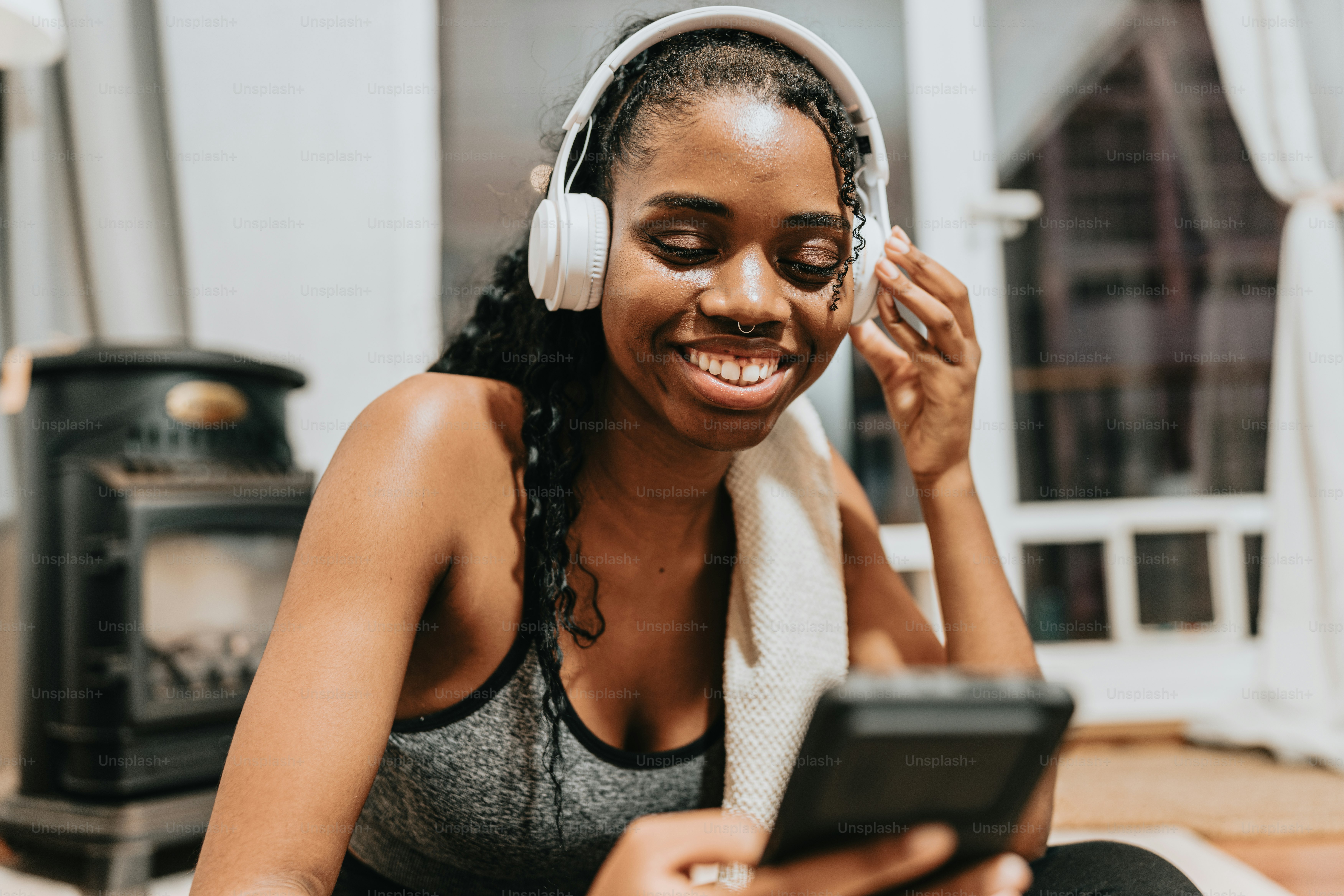 a woman sitting on the floor listening to music on her phone