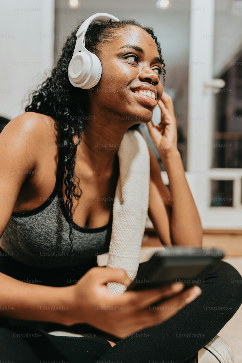a woman sitting on the floor listening to music with headphones